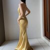 gold formal gown with plunging neckline, adjustable straps and figure hugging mermaid skirt