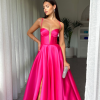fuchsia formal gown with deep v neck illusion, high side slit, lace up back, and spaghetti strap