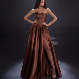 Clara Gown in Burnt Umber satin featuring a strapless sweetheart neckline, draped bodice, drop waist, full skirt and high leg split.